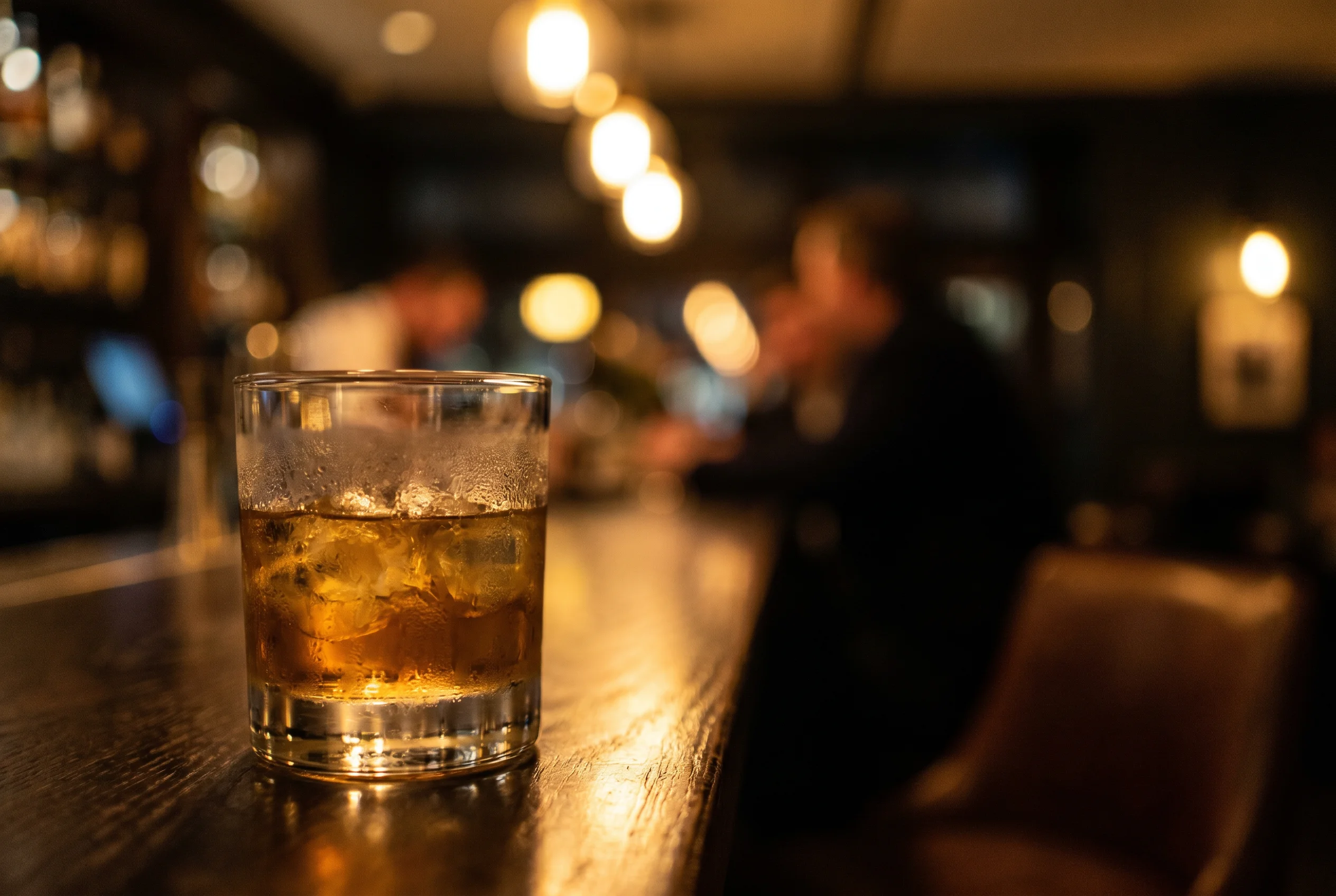 Lobby-Bar des relexa — Bar-Detail · Whisky-Tumbler · warmes Licht