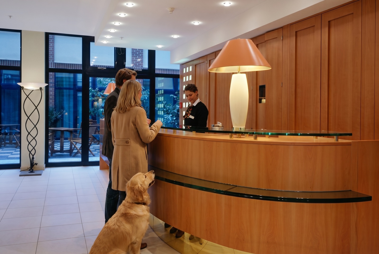 Pärchen mit Golden Retriever beim Check-in an der Rezeption des relexa hotels