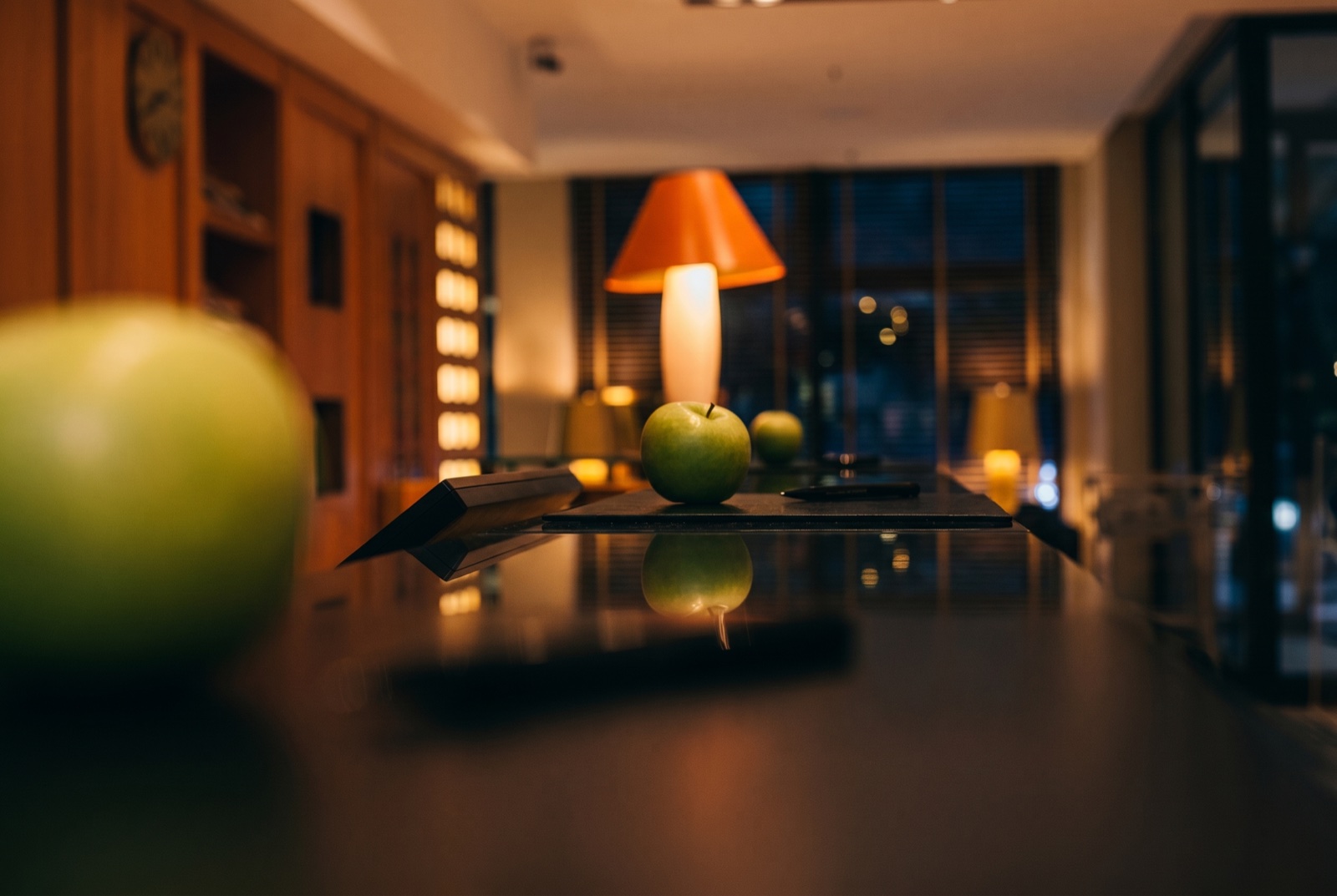 Hotellobby spät in der Nacht — warmes Lampenlicht über dem Empfangstresen